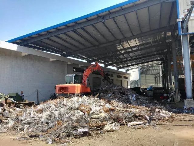 晉工輪挖在進行廢舊鐵皮的堆放作業